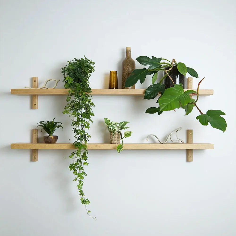 Elegant hylde i egetræ med planter og dekorationer, produceret i Europa med fokus på dansk design.